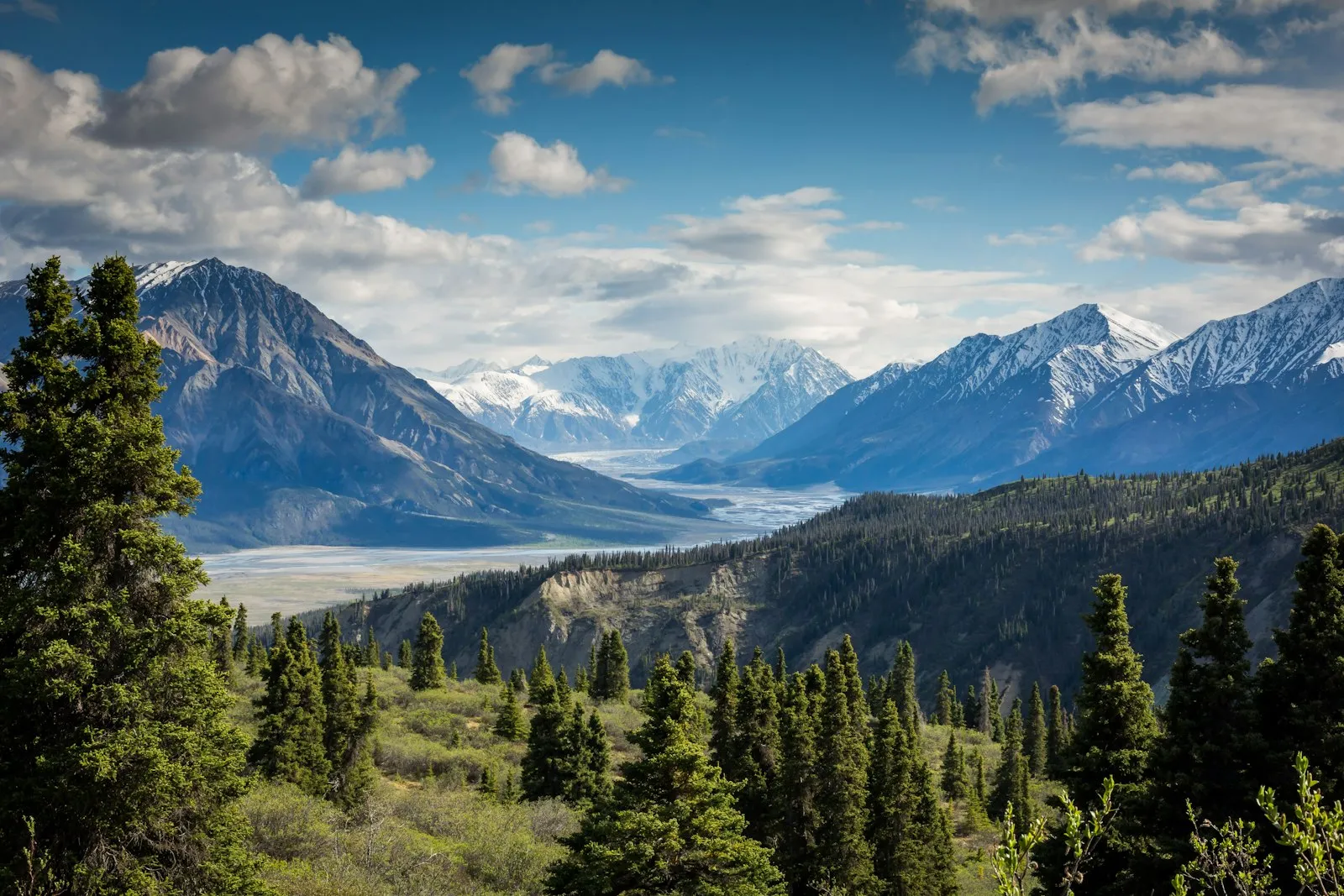 Snow-covered alpine mountains beneath a bright sky